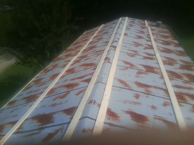 Rusted metal roof panels with new wood purlins before replacement — Storm Damage Roof Repair in Upland by Roofing Brothers