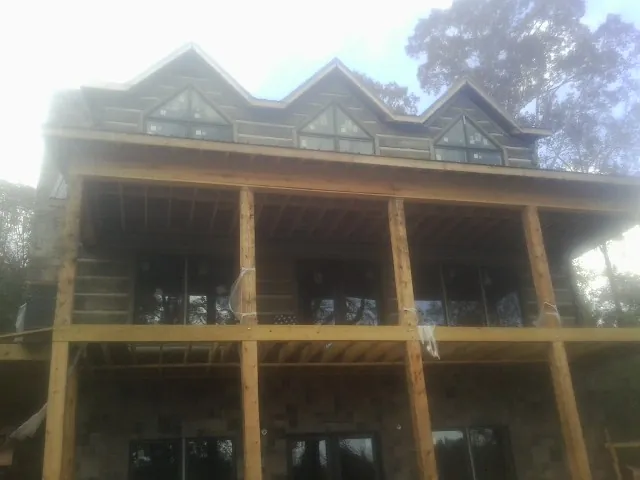 Dormers and porch framing on a large log home under construction — Roof Coating work by our crew in Upland