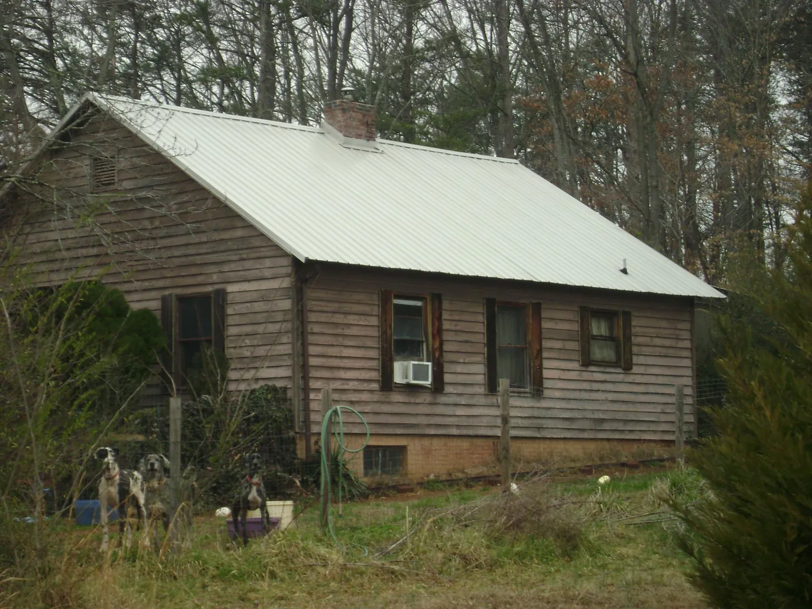 White metal roof on an old wood sided farmhouse, from a Metal Roof Installation job in Upland